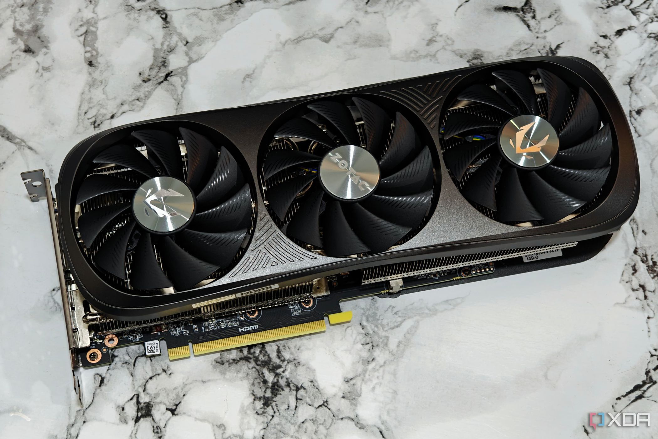 Изображение графического процессора Zotac Gaming GeForce RTX 4070 Super, лежащего на столе.