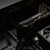 Открытый корпус компьютера с установленной видеокартой Gigabyte рядом с радиатором процессора AMD и твердотельным накопителем Samsung.