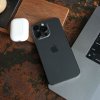 iPhone 15 Pro Max лежит на ноутбуке.