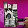 Изображение Raspberry Pi 5 перед монитором, на котором отображается рабочий стол Ubuntu GNOME по умолчанию.