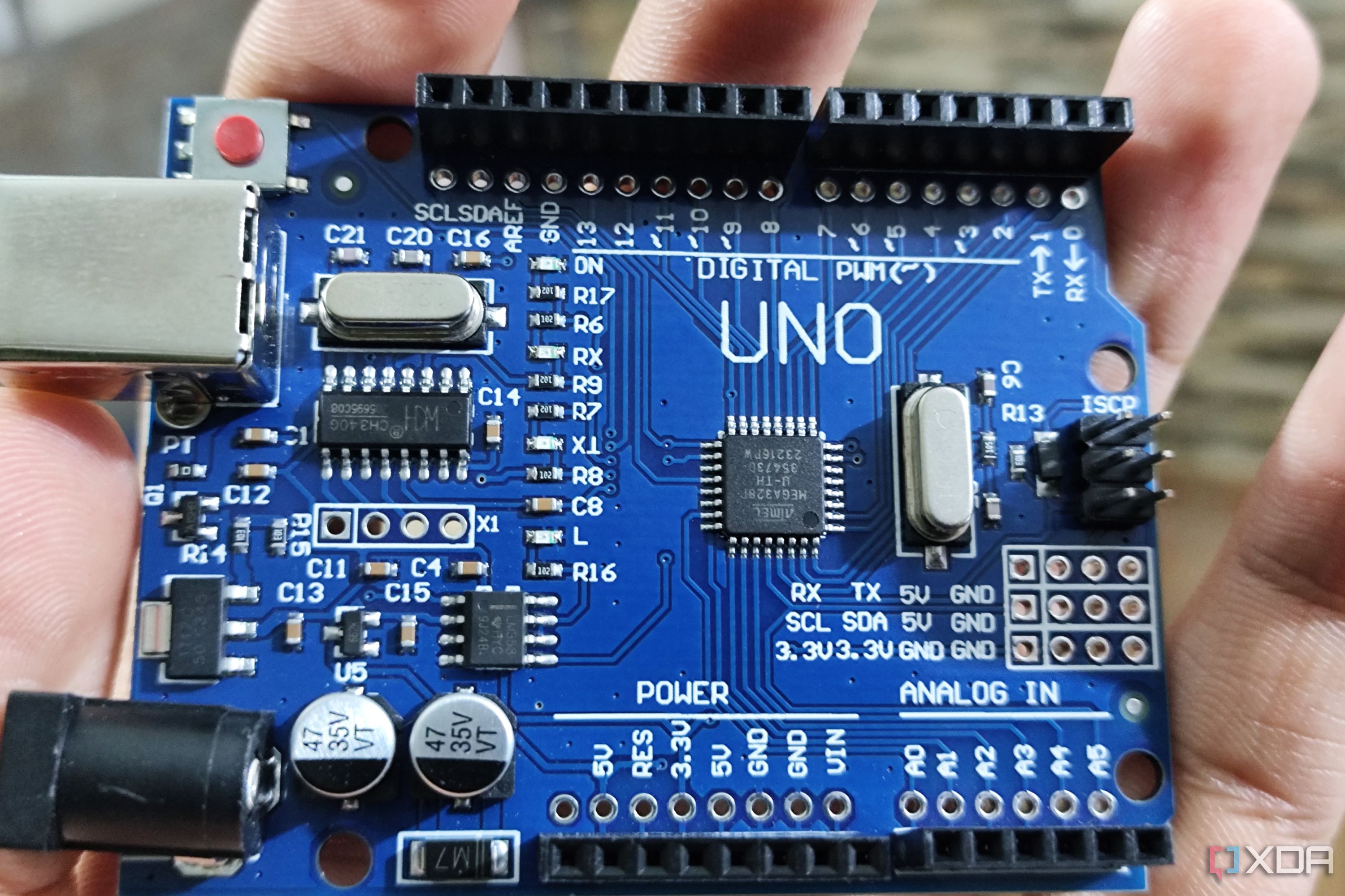 Человек, держащий Arduino Uno 