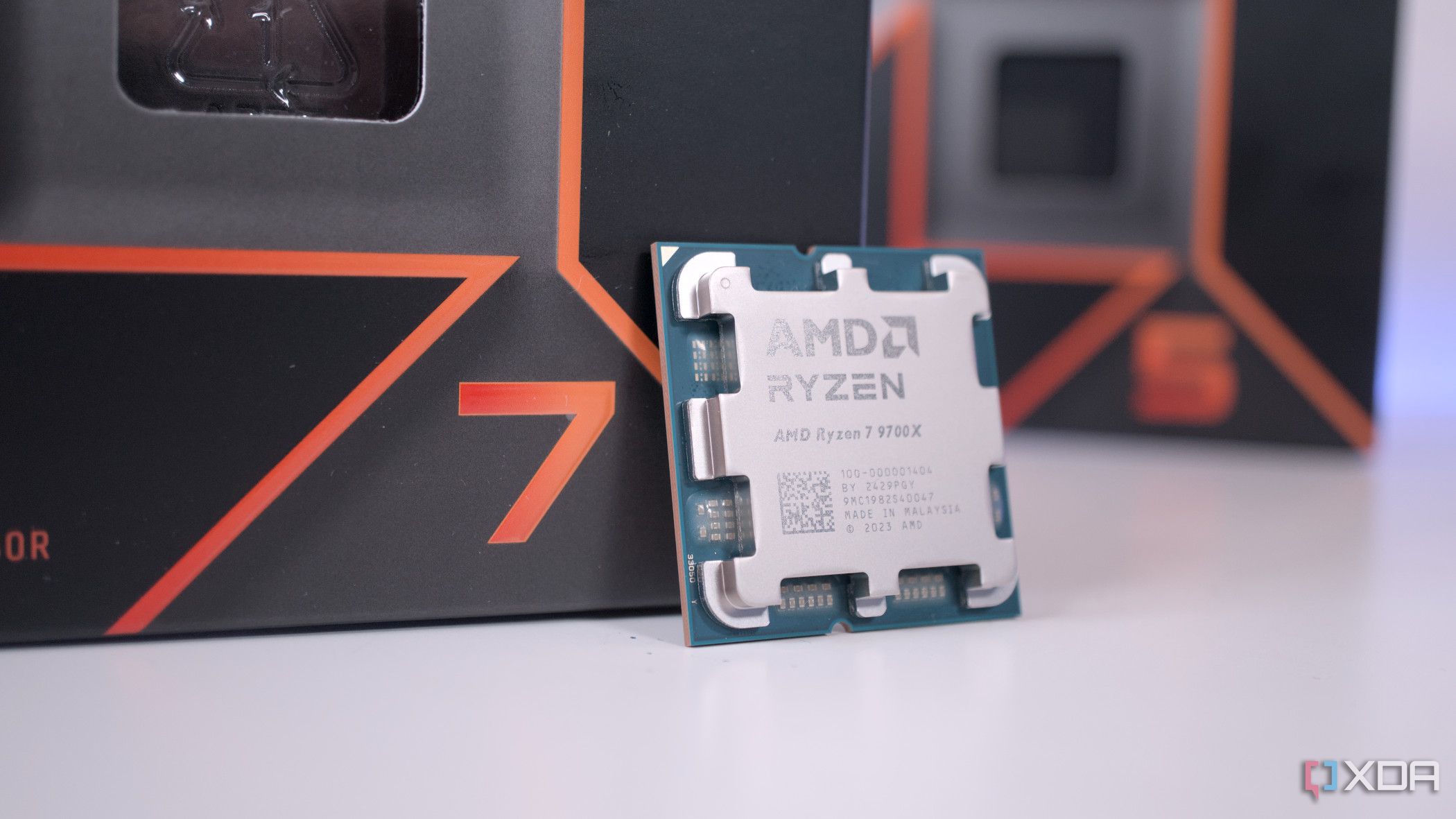 AMD Ryzen 7 9700X перед коробкой Ryzen 5