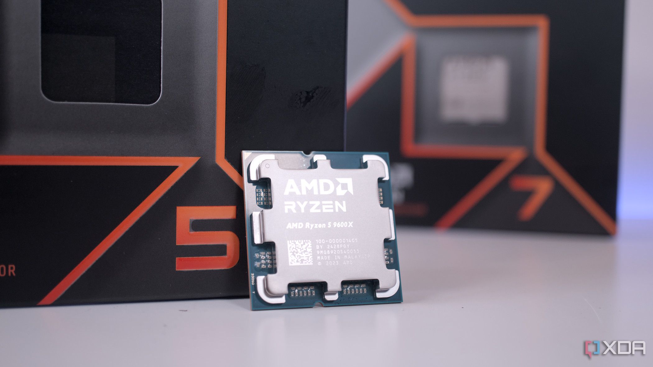 AMD Ryzen 5 9600X перед коробкой Ryzen 7